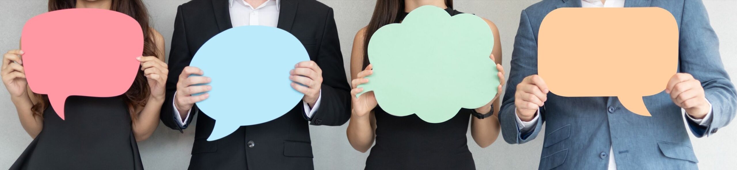iStock-2179519527 narrow Business People Holding Speech Bubbles While Standing Indoors
